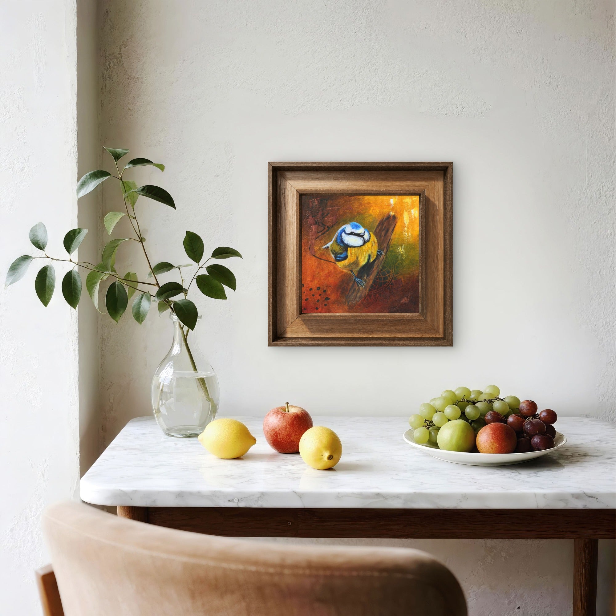 A small dining room decorated with cut plants of fruits an featuring a framed painting of blue tit.
