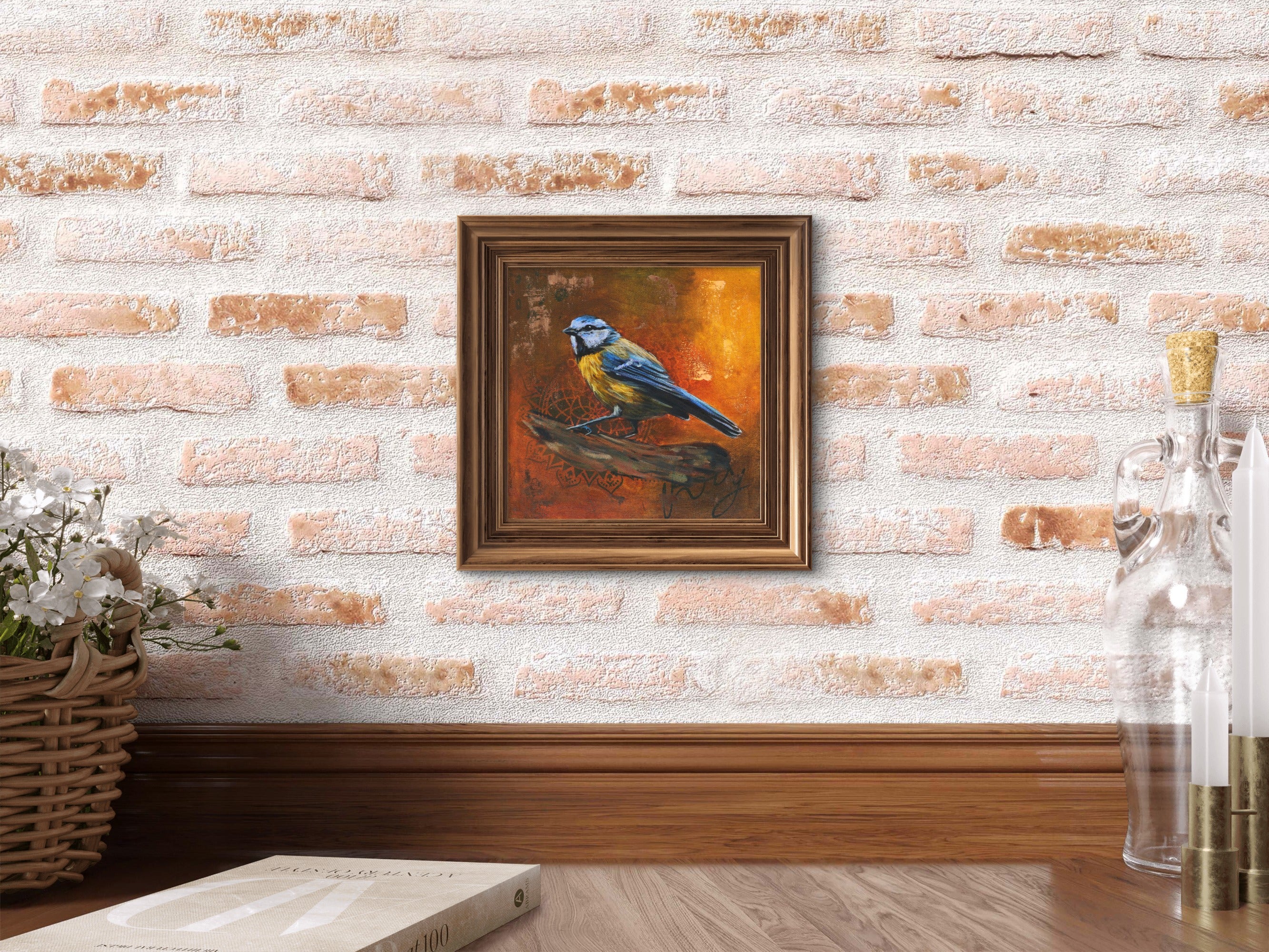 framed painting of a blue tit hanged on a brick wall.