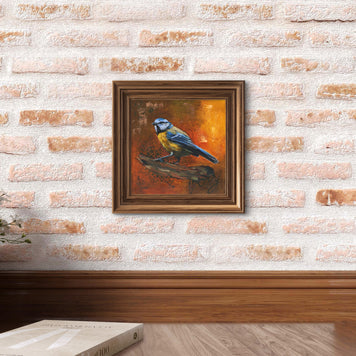 framed painting of a blue tit hanged on a brick wall.