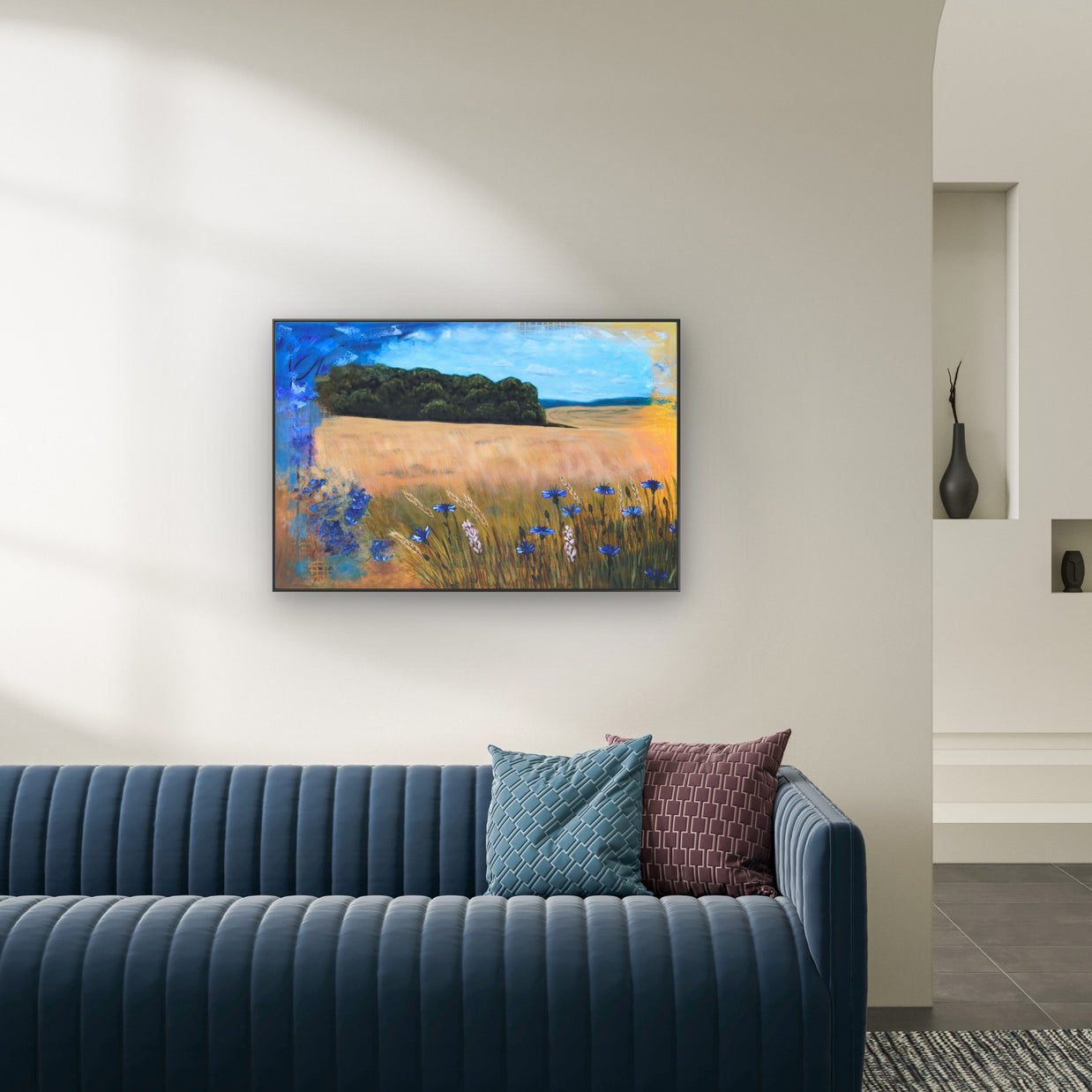 modern living room with dark blue sofa featuring a painting of field with cornflowers.