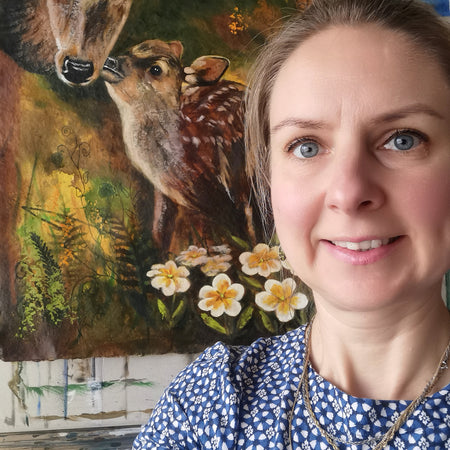 Woman in front of a painting of two deer and flowers