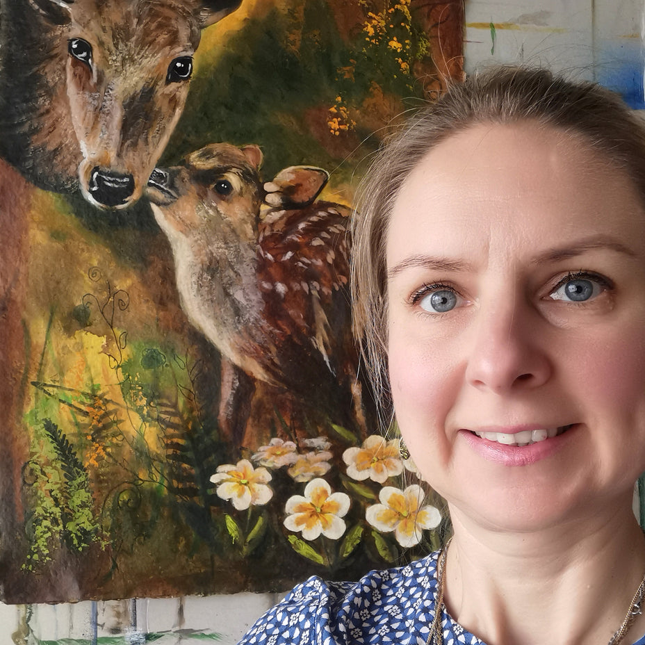 Woman standing next to a painting of two deer and flowers