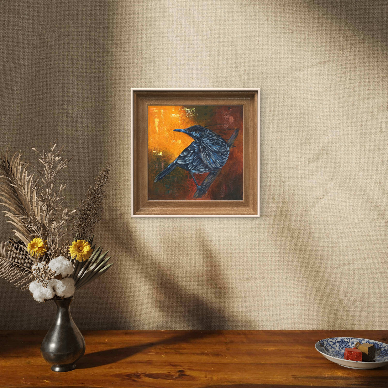 Framed painting of a starling on a wall.