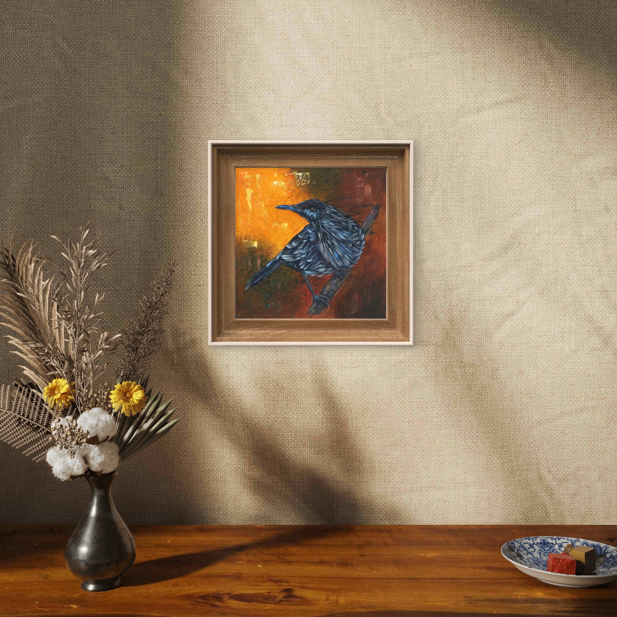 Framed painting of a starling on a wall.