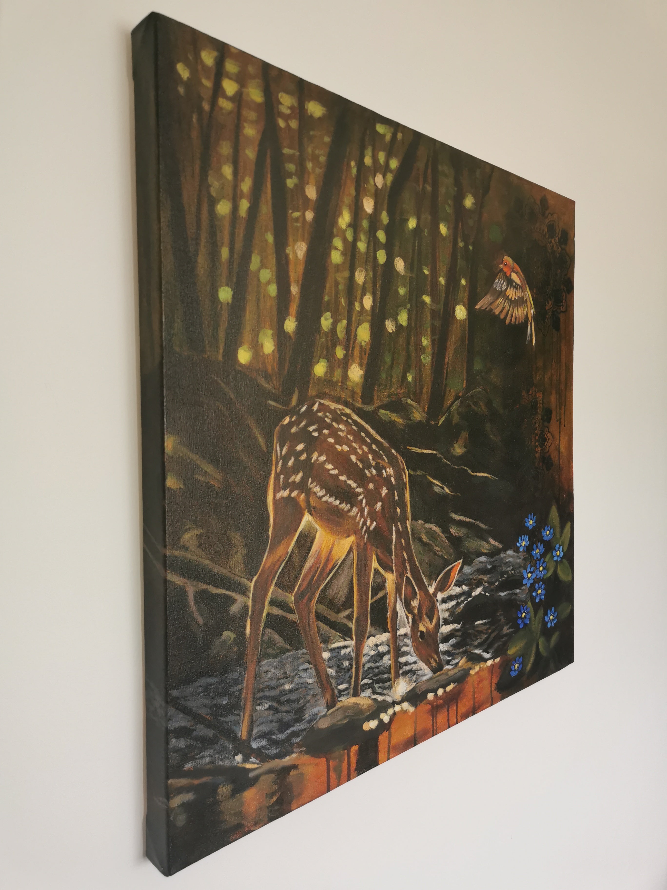 Stunning side view of a fawn in a forest scene with a bird